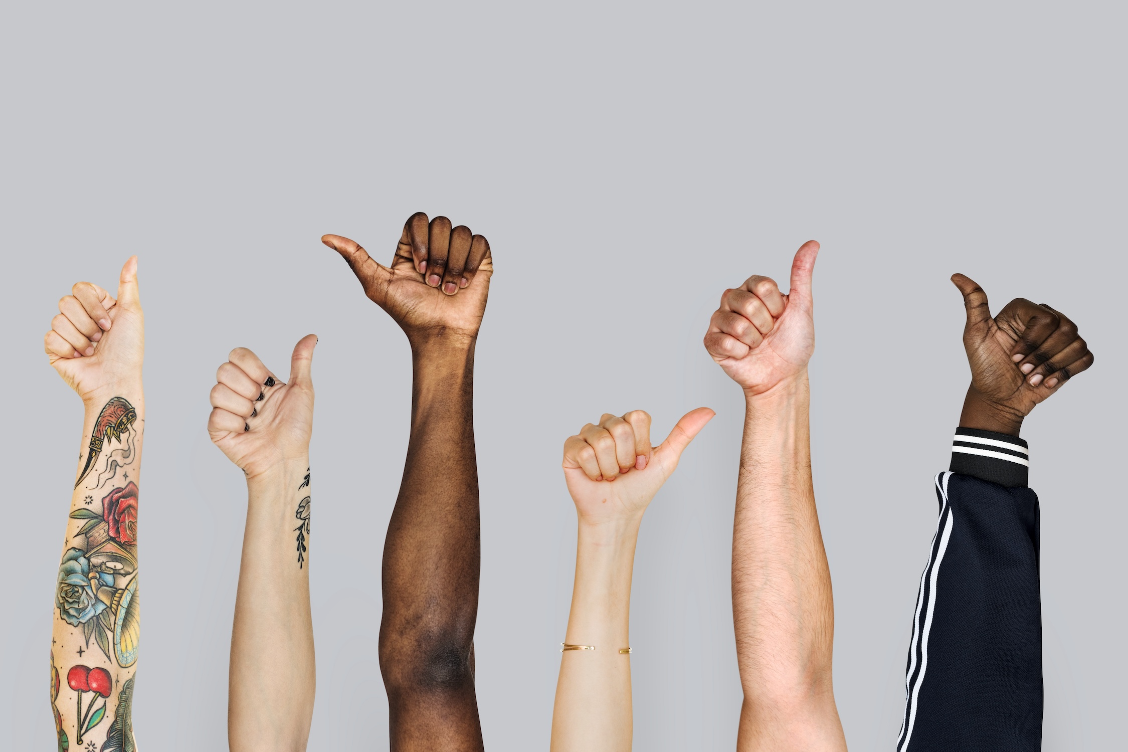 Diverse workers giving the thumbs up sign to deal with positive results