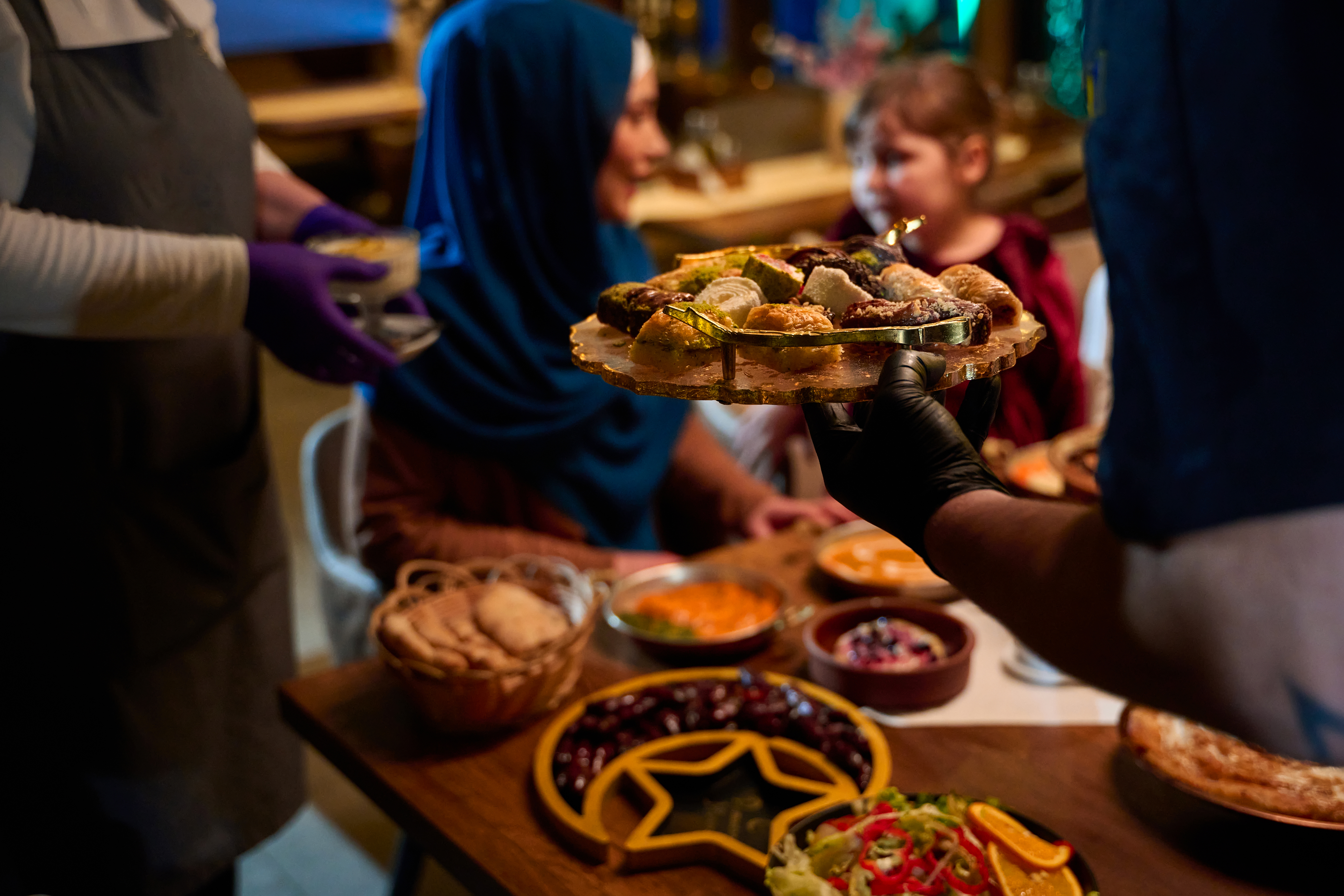 In a heartwarming scene a professional chef serves Mediterranean cuisine to a table of male and female guests
