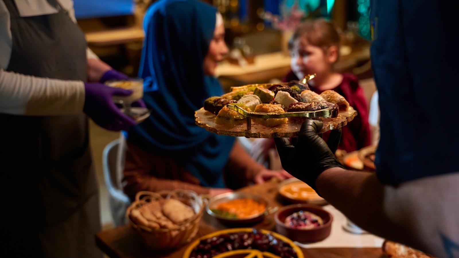 In a heartwarming scene a professional chef serves Mediterranean cuisine to a table of male and female guests